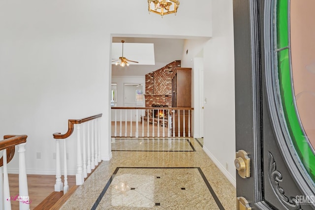 hall featuring an upstairs landing, granite finish floor, and baseboards
