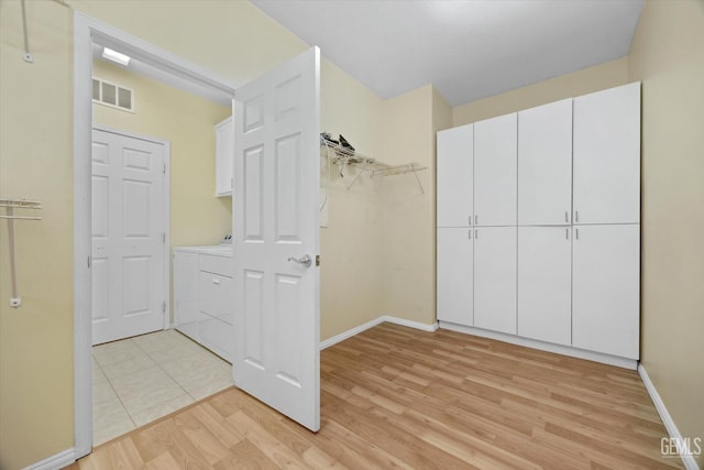 10002 Riata Ln, Bakersfield, CA 93306 - walk in closet with washer / dryer and light wood-style flooring