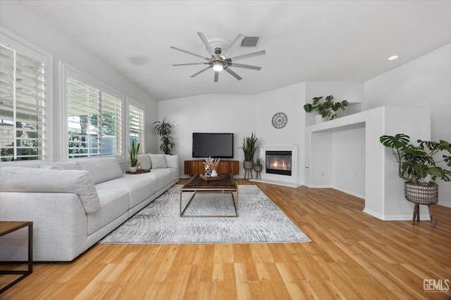 10002 Riata Ln, Bakersfield, CA 93306 - living area with wood finished floors, ceiling fan, a glass covered fireplace, and baseboards