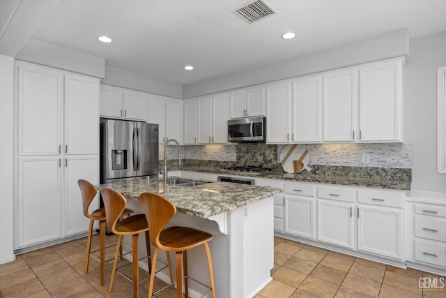 10002 Riata Ln, Bakersfield, CA 93306 - kitchen featuring stainless steel appliances, a sink, light stone countertops, backsplash, and white cabinets