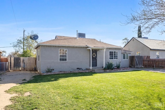 view of front facade featuring a fenced backyard, a front lawn, a shingled roof, and stucco siding