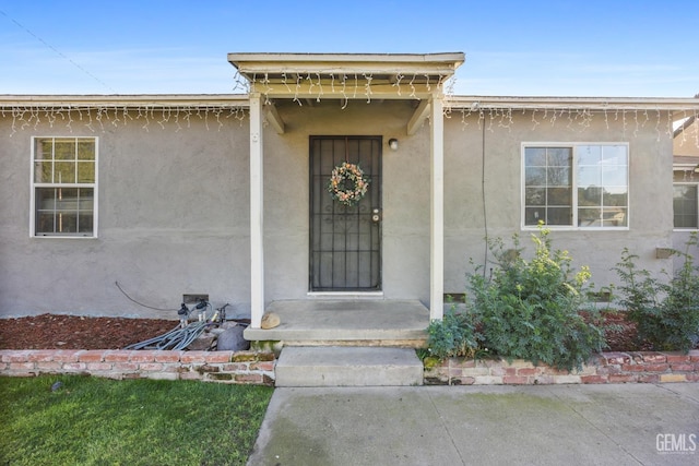 doorway to property featuring stucco siding