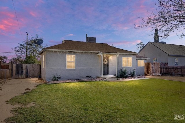 view of front of house featuring a chimney, fence, a front lawn, and stucco siding