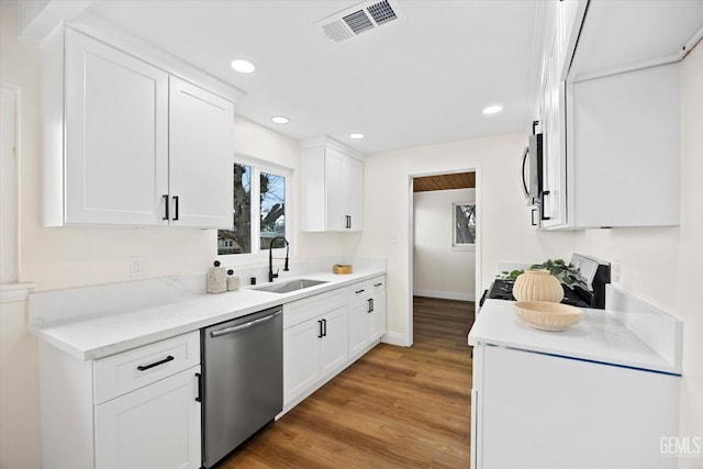 kitchen with stainless steel appliances, light hardwood / wood-style floors, sink, and white cabinets