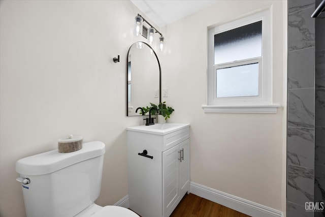 bathroom featuring vanity, hardwood / wood-style flooring, and toilet