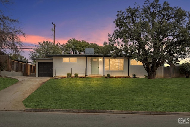 view of front of house featuring a garage and a yard