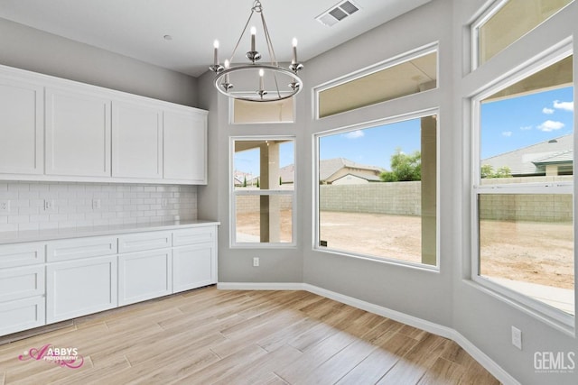 unfurnished dining area featuring a chandelier and a healthy amount of sunlight