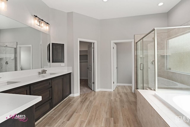 bathroom featuring hardwood / wood-style flooring, vanity, and separate shower and tub