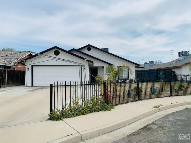 view of front of property featuring a fenced front yard, concrete driveway, an attached garage, and stucco siding