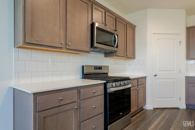 kitchen featuring decorative backsplash, dark wood-type flooring, and appliances with stainless steel finishes