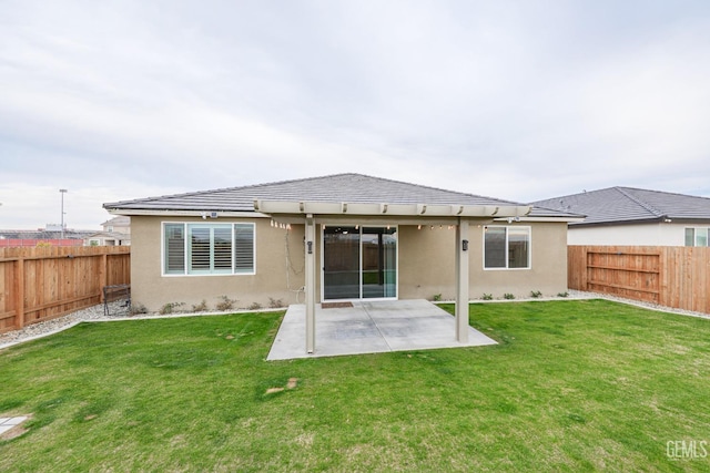 back of property with a lawn and a patio area