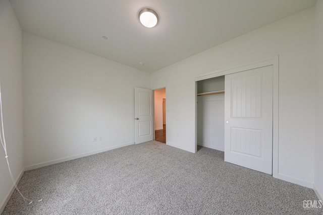 unfurnished bedroom featuring carpet flooring and a closet