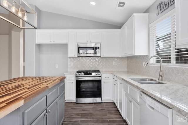 kitchen with wood counters, white cabinetry, and appliances with stainless steel finishes