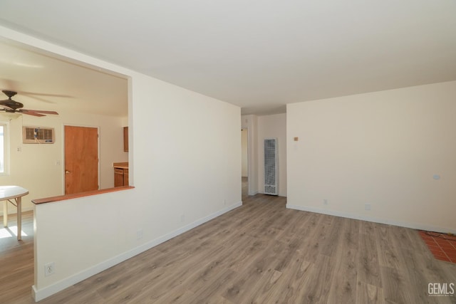 unfurnished room with light wood finished floors, baseboards, a ceiling fan, and a wall mounted AC