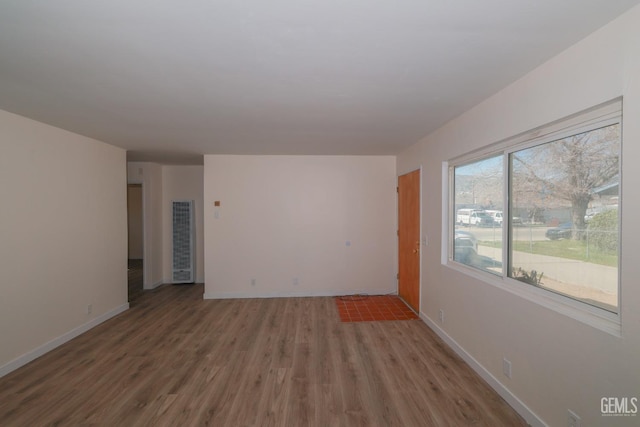 empty room featuring baseboards and wood finished floors