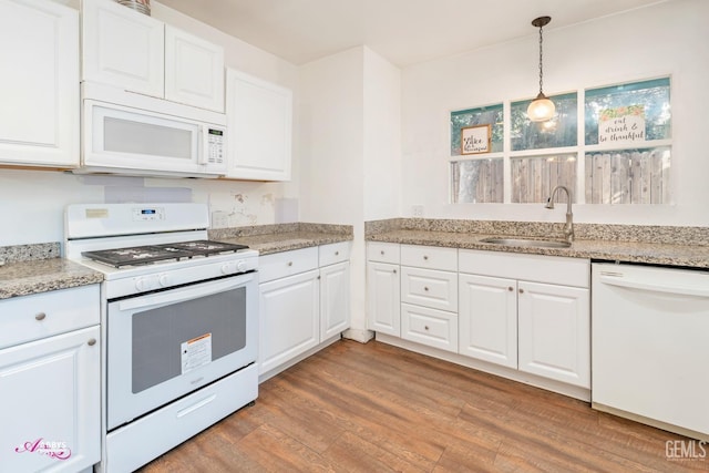 kitchen with white cabinetry, sink, pendant lighting, white appliances, and light wood-type flooring