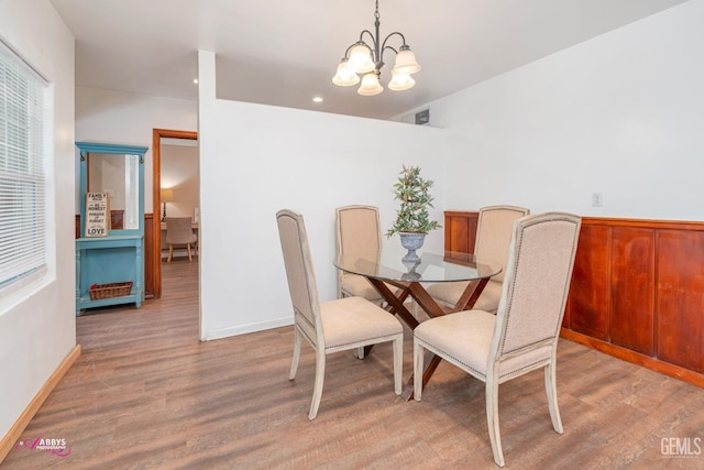 dining room with hardwood / wood-style flooring and an inviting chandelier