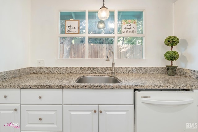 kitchen featuring dishwasher, pendant lighting, white cabinetry, and sink