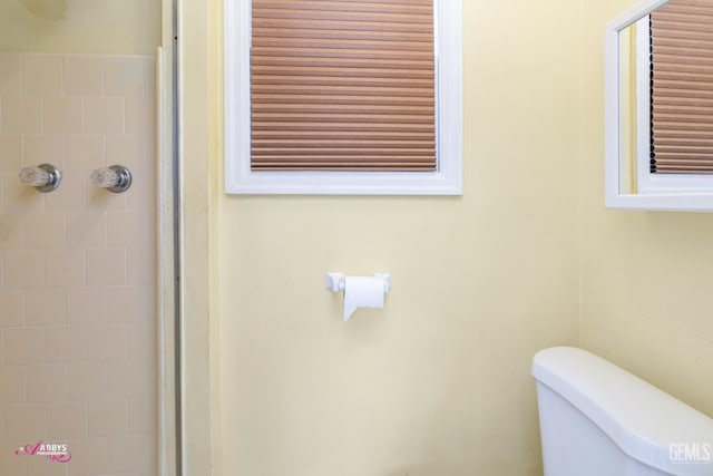 bathroom with tiled shower and toilet