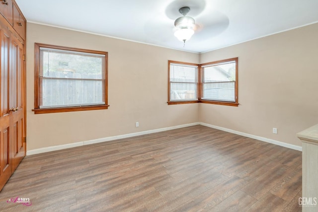 empty room with hardwood / wood-style flooring and ceiling fan