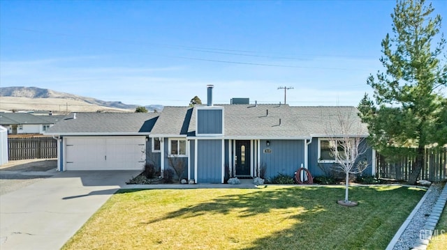 single story home with a mountain view, a garage, and a front lawn