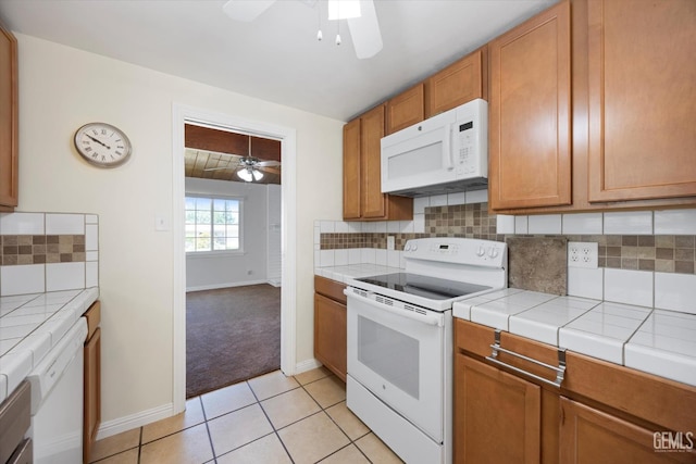 3117 Arnold St, Bakersfield, CA 93305 - kitchen featuring white appliances, ceiling fan, tile counters, tasteful backsplash, and light tile patterned floors
