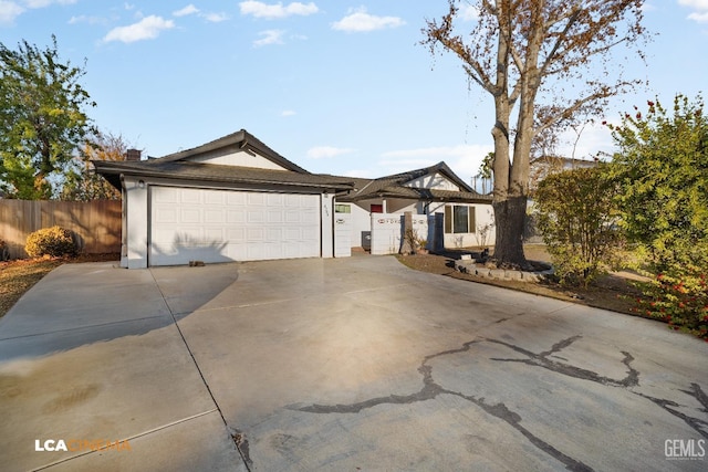 single story home with a garage, fence, and driveway