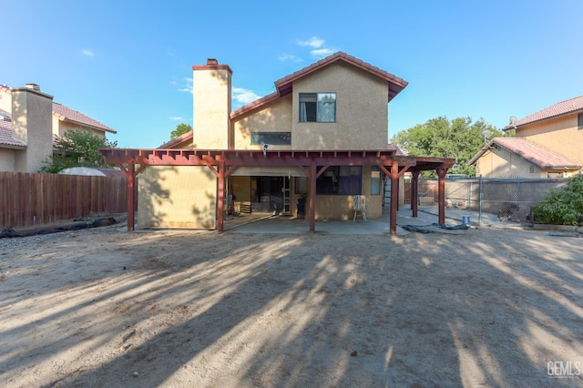 44827 Rock Island Dr, Lancaster, CA 93535 - back of property featuring a chimney, stucco siding, and a patio area