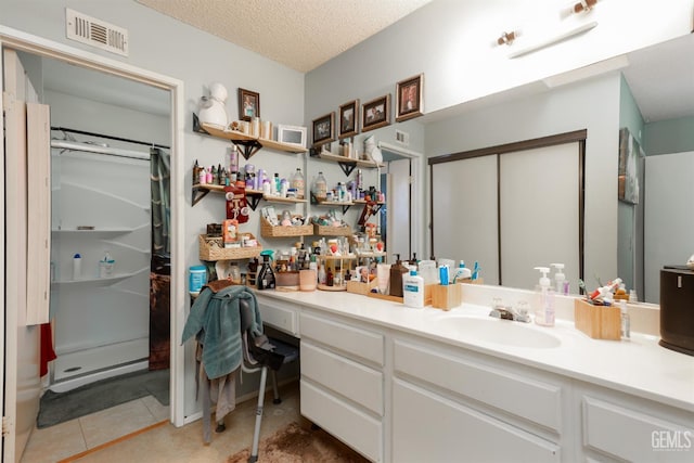 44827 Rock Island Dr, Lancaster, CA 93535 - full bath featuring vanity, a stall shower, tile patterned floors, and a textured ceiling