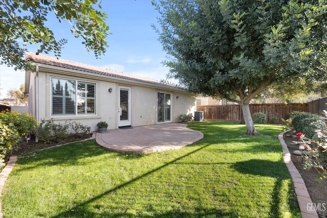 back of house featuring cooling unit, fence, a yard, stucco siding, and a patio area