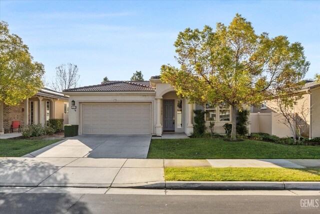 view of front of home with a front yard and a garage