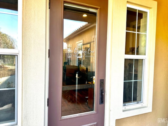 view of exterior entry with stucco siding