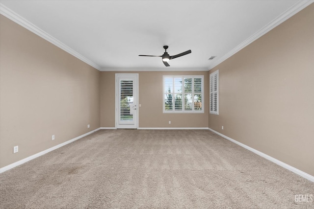 carpeted empty room featuring crown molding, a ceiling fan, visible vents, and baseboards