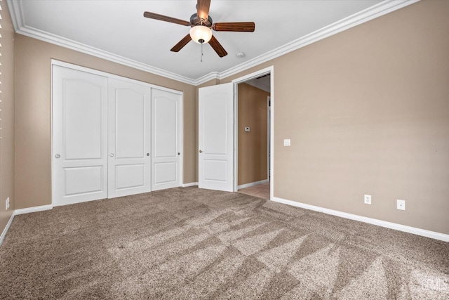 unfurnished bedroom featuring a closet, baseboards, carpet flooring, and crown molding