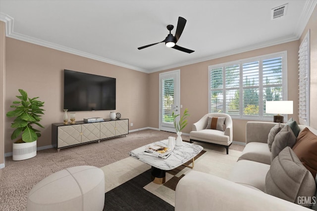 carpeted living area featuring visible vents, plenty of natural light, baseboards, and ornamental molding