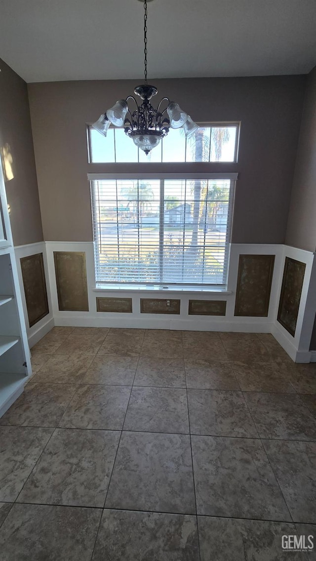 unfurnished dining area with a wealth of natural light and an inviting chandelier