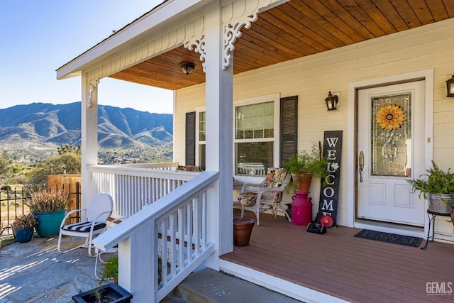 view of exterior entry with a mountain view and a porch