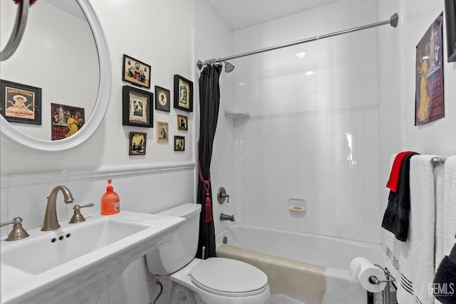 full bathroom with shower / tub combo with curtain, toilet, sink, and tile walls