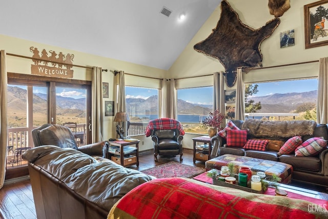 living room with a mountain view, hardwood / wood-style floors, and high vaulted ceiling