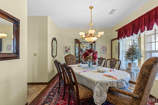 tiled dining space with a notable chandelier