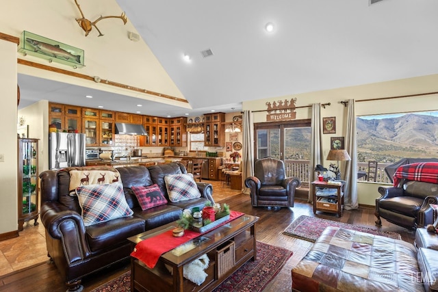 living room with high vaulted ceiling and wood-type flooring