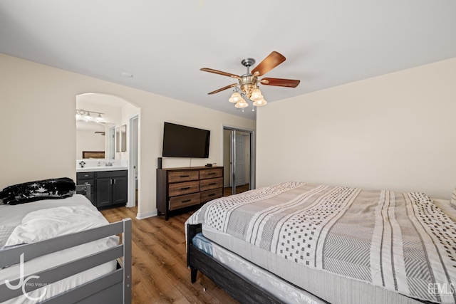 13421 Cheyenne Mountain Dr, Bakersfield, CA 93314 - bedroom with arched walkways, light wood-style flooring, a closet, ceiling fan, and ensuite bath