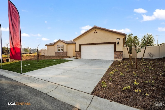 mediterranean / spanish home featuring fence, a garage, driveway, and stucco siding