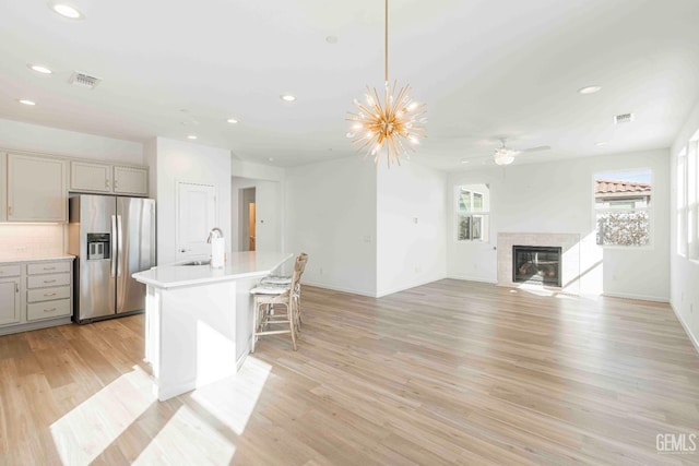 14209 Boon Way, Bakersfield, CA 93311 - kitchen featuring gray cabinets, pendant lighting, an island with sink, stainless steel fridge, and backsplash