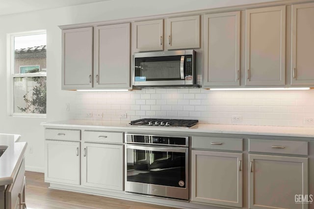 14209 Boon Way, Bakersfield, CA 93311 - kitchen featuring stainless steel appliances, tasteful backsplash, gray cabinets, and light wood-type flooring