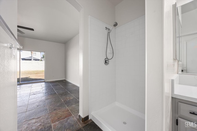 bathroom with ceiling fan, vanity, and a tile shower