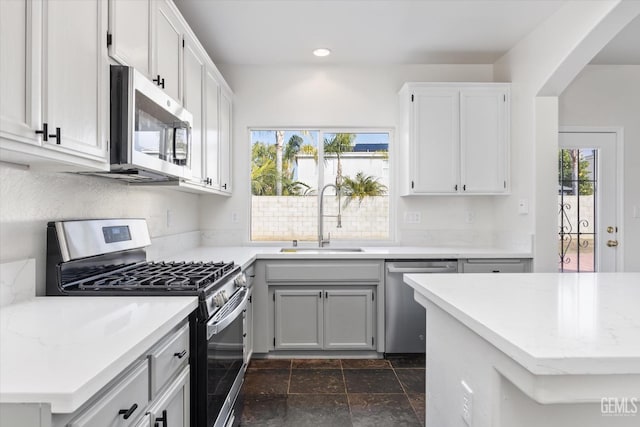 kitchen with white cabinetry, stainless steel appliances, sink, and plenty of natural light