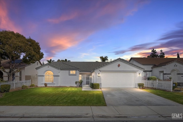 ranch-style house with a garage and a lawn