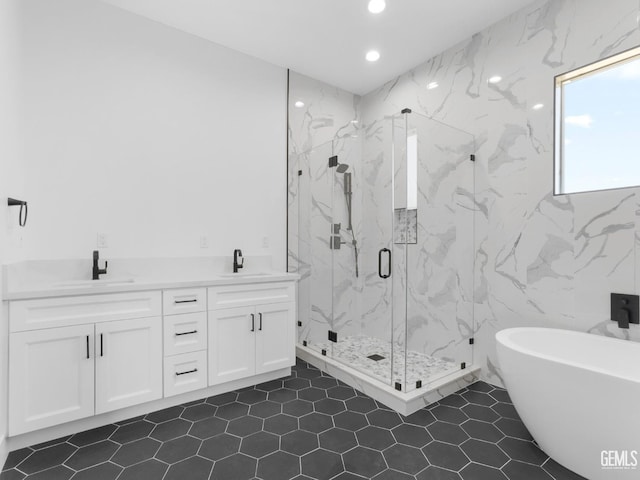 full bathroom featuring recessed lighting, a freestanding tub, a sink, and a marble finish shower