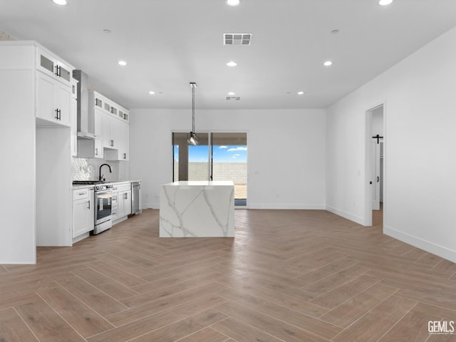 kitchen featuring stainless steel appliances, recessed lighting, visible vents, decorative backsplash, and wall chimney exhaust hood